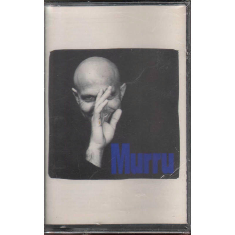Copertina del disco omonimo di Marcello Murru, uscito nel 1992 per Micocci IT Dischi: un'audiocassetta con sfondo bianco e al centro una fotografia in bianco e nero, forse in formaot polaroid, con la foto di un uomo di mezza età calvo sorridente che si copre parzialmente il volto con la mano sinistra. La scritta "Murru" in blu scuro appare in basso a sinistra sullo sfodno nero della foto.